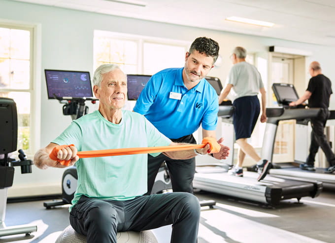 A trainer works out with a resident.