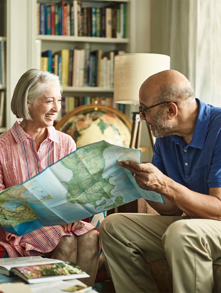 Man and woman on couch looking at map. 