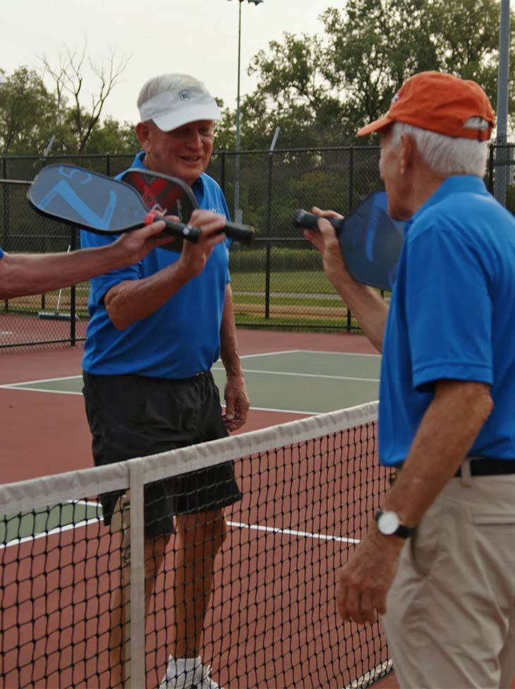 Men playing pickleball.