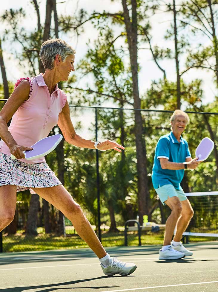 A man and women playing pickleball.