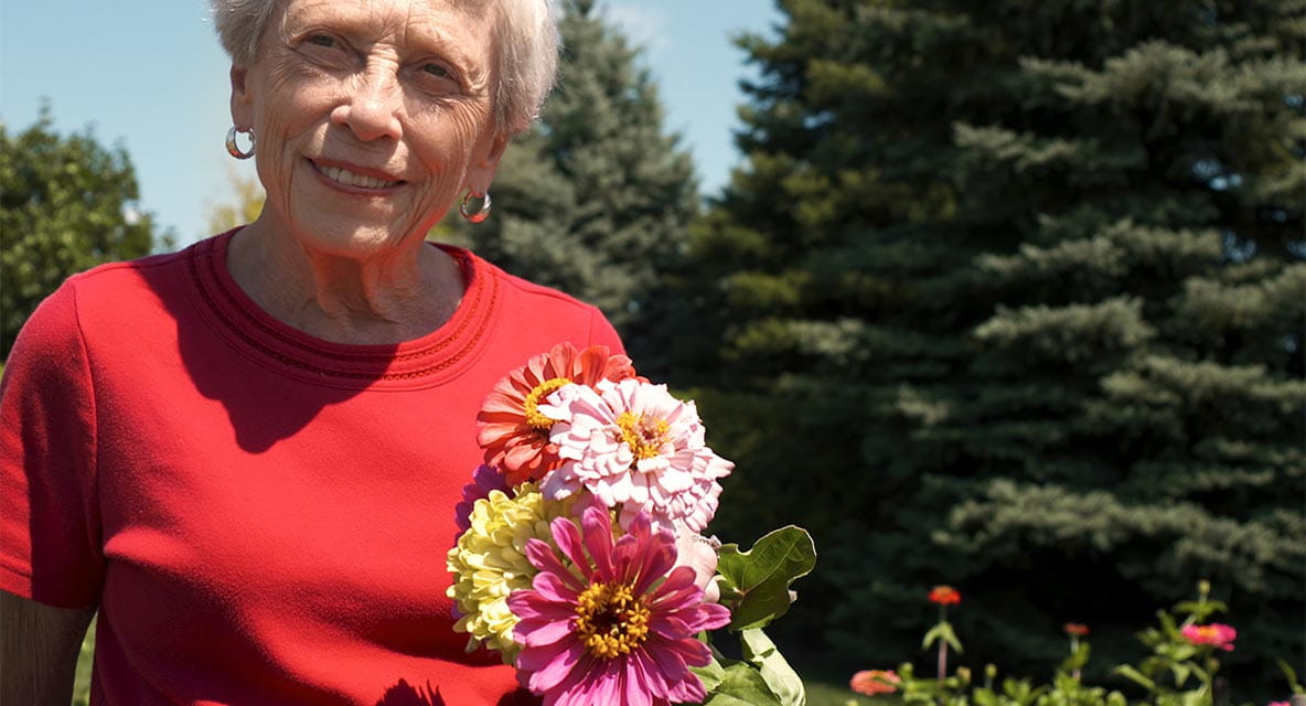Women holding flowers outside.