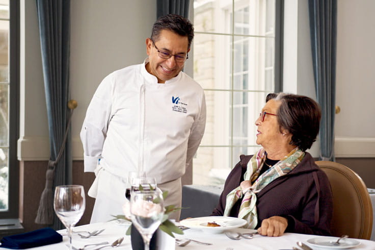 Chef Jose Luna chats with a resident.
