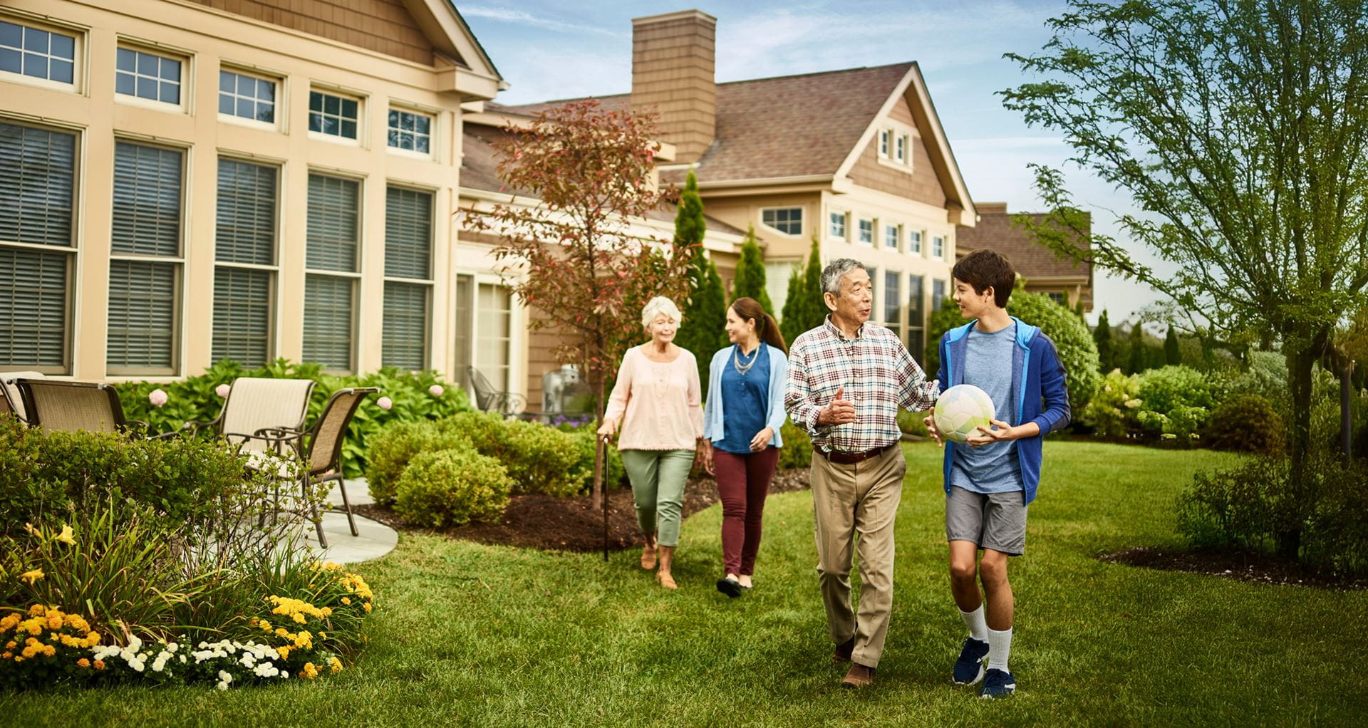 A multi-generational family walks by the Vi at The Glen villas.