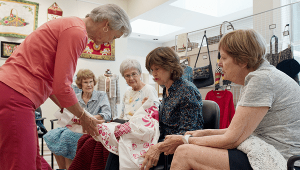 Women gather around a sewing project.