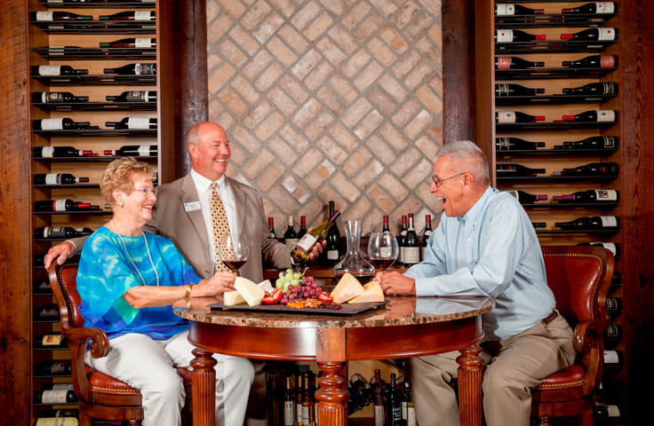 A couple laughs with the sommelier.