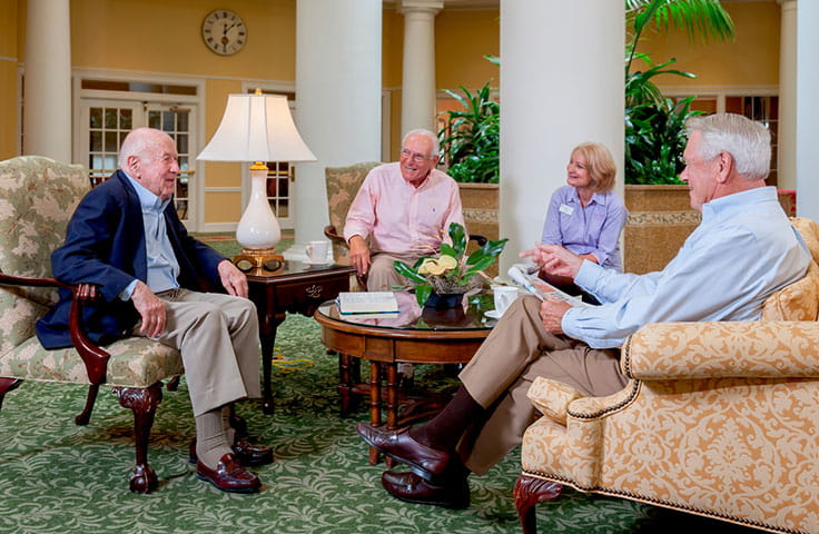 Three men and a woman sit and chat.