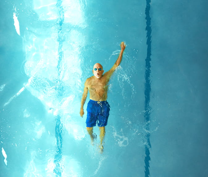 A man swimming backstroke in a pool.