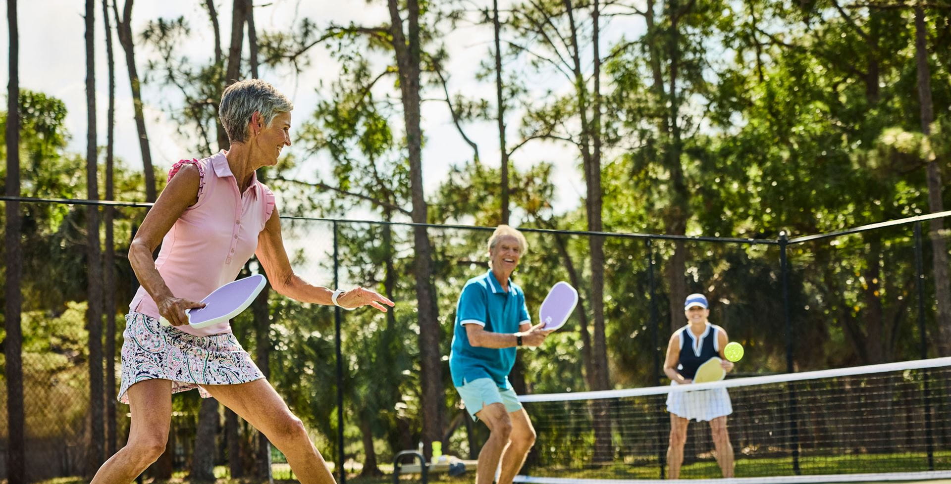 Two women and a man play pickleball on Vi at Lakeside Village's court.