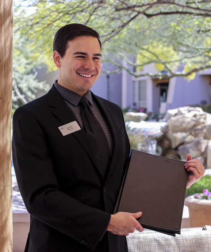 A staff member displays a menu.