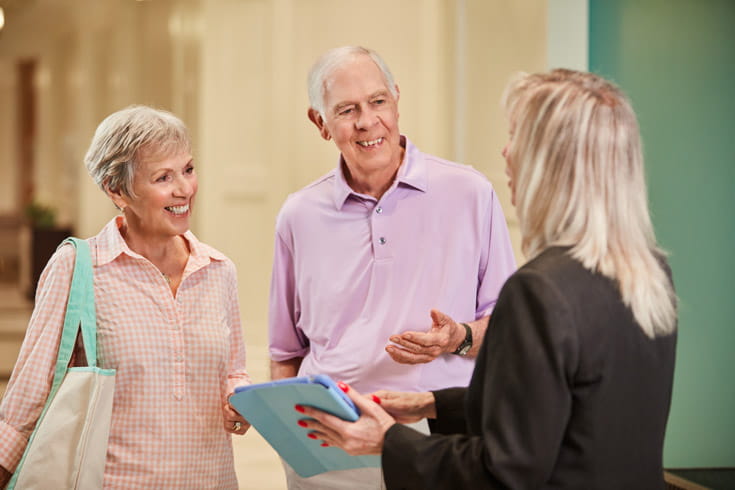 A couple speaks to a salesperson.