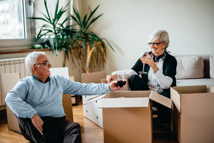 A man and woman toast while packing.