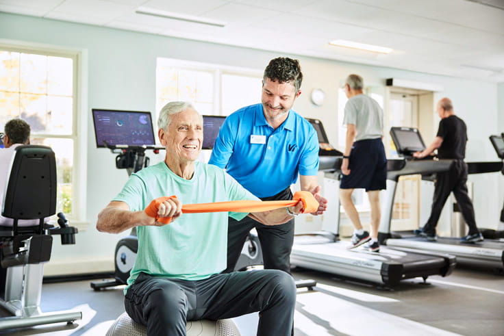 A Vi resident works with a fitness instructor.