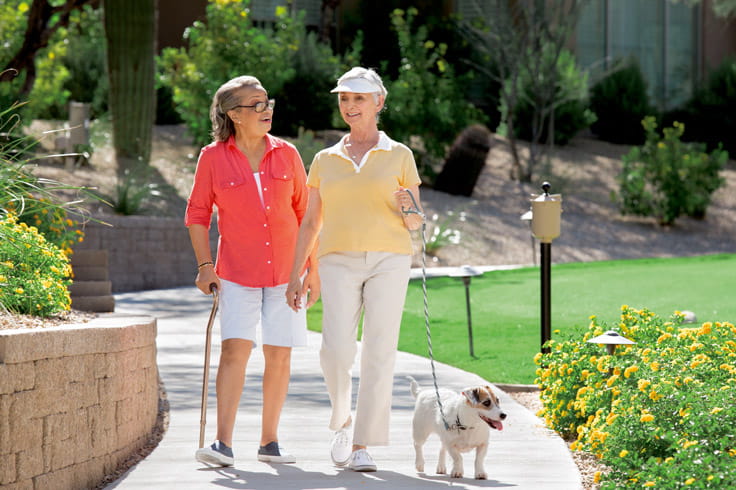 Two women walk down a path together.