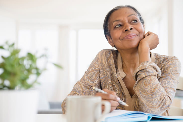 A Black woman looks to the side in thought.