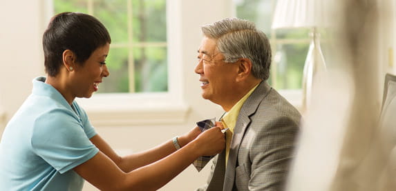 A woman ties a man's bow tie.