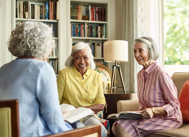 Three women meet to discuss books at a Vi community.