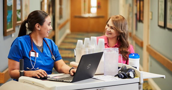 Two nurses chat in the care center.