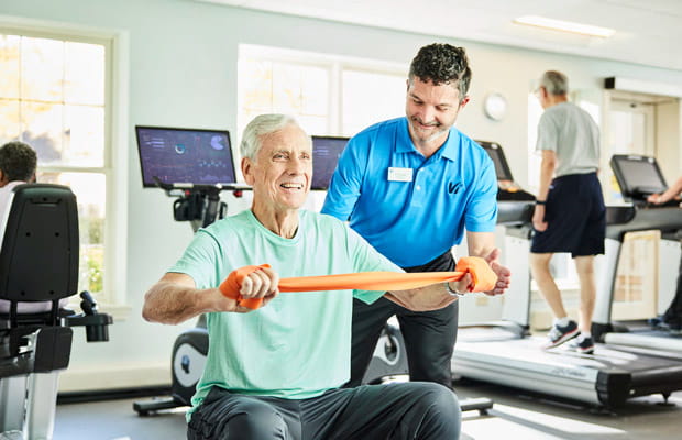 A man stretches with a Vi fitness coordinator.