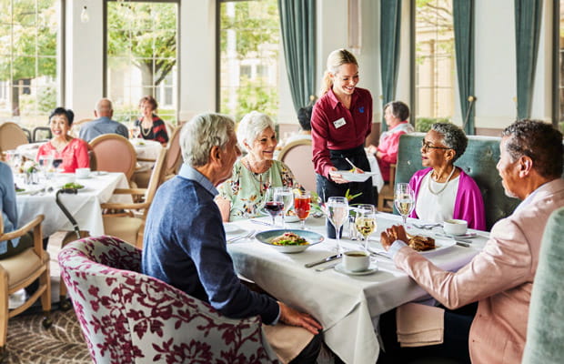 A table of diners receives their dinner plates.
