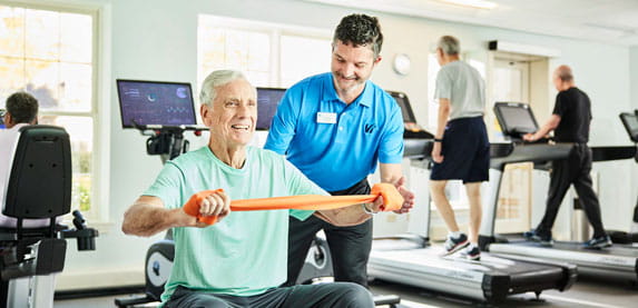 A man works with a personal trainer.