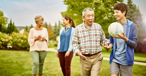 A multigenerational family walks outside.