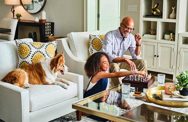 A grandpa and granddaughter playing chess. 
