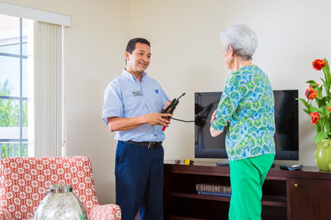 A Vi employee performs maintenance in a resident's apartment.