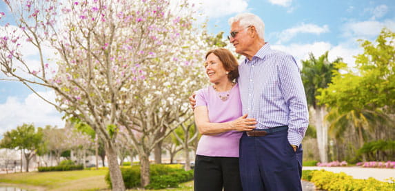 A couple looks over a pond at Vi at Bentley Village.