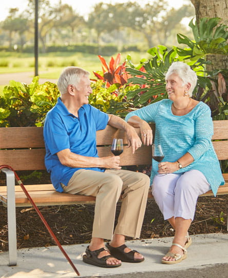 A man and woman talk on a bench.