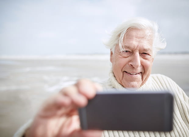 A man uses his mobile phone near the water.