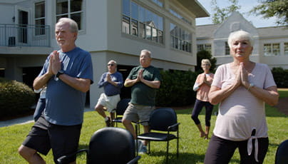 TidePointe members do chair yoga outside.